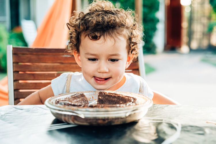 Cute girl looking at cake on table