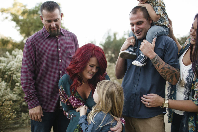 Happy family looking at daughter on field