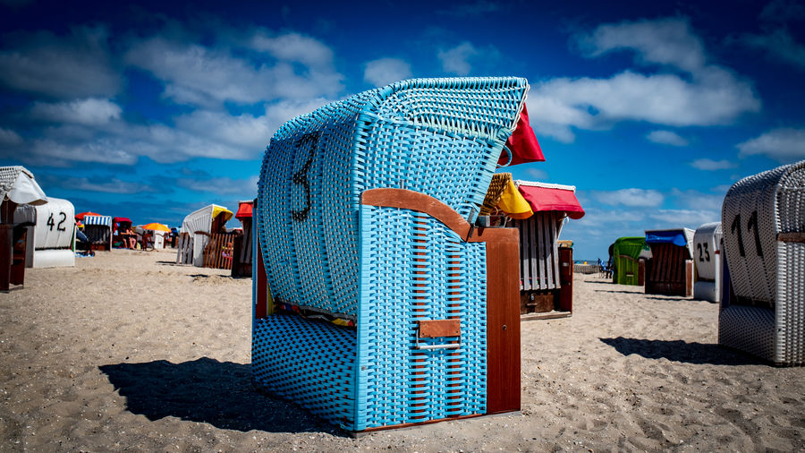 Hooded beach chair against blue sky during sunny day