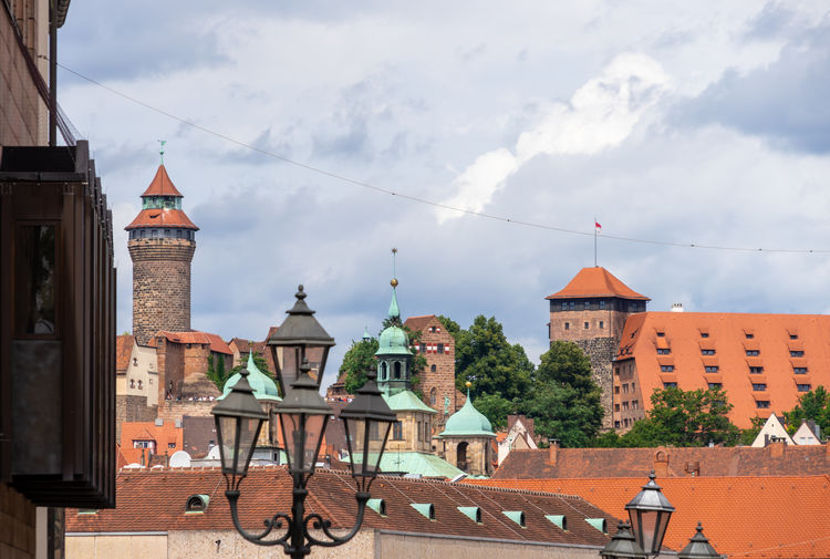 Buildings in city against cloudy sky