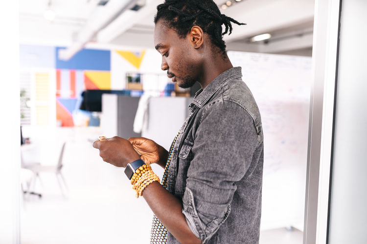 Side view of man using phone in office