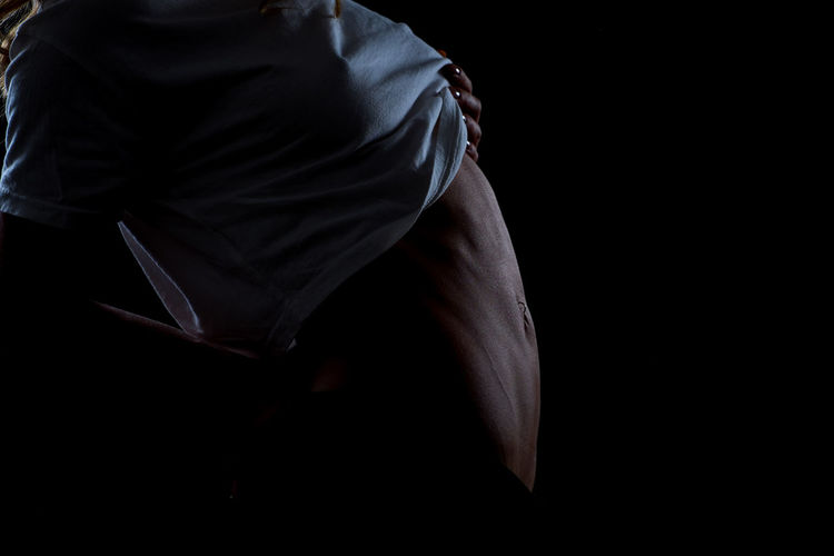 Midsection of woman over black background