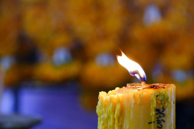 Close-up of burning candles on cutting board