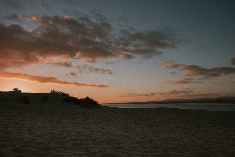 Scenic view of beach against sky during sunset