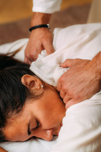 Shiatsu arms and shoulder massage. therapist massaging the small and large intestine meridians.