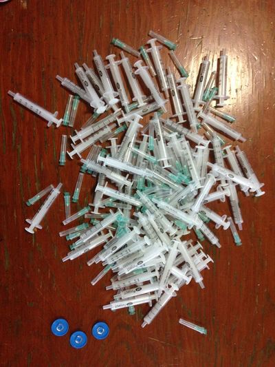 Close-up of syringes on wooden table