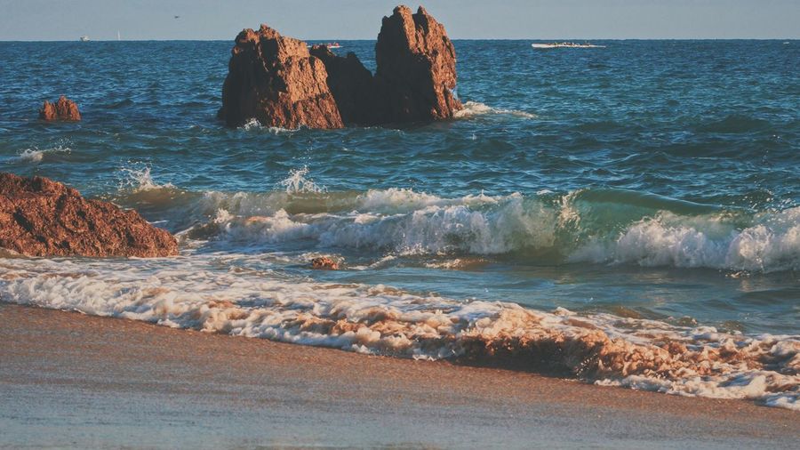 Scenic view of rocks in sea against sky