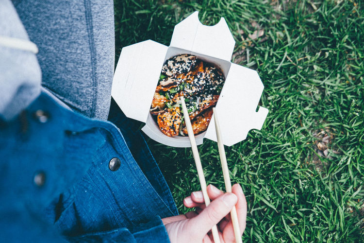 Midsection of person with food on grass
