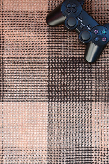 Directly above shot of game controller on textile
