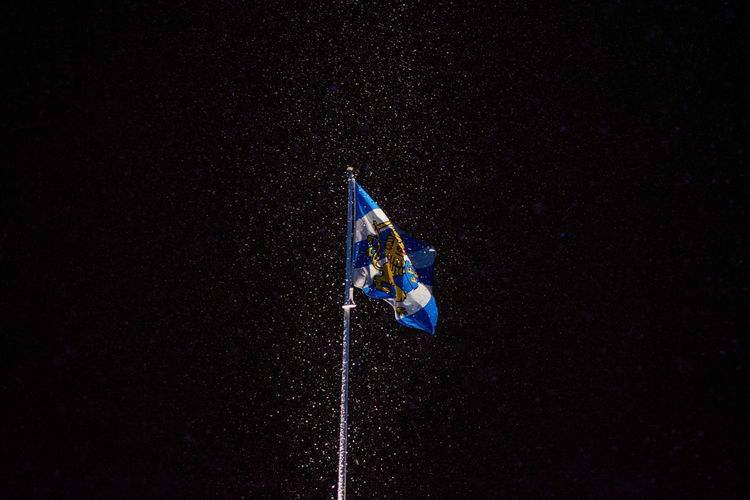 Blue flag waving against black background