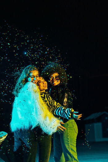 Young smiling women throwing confetti on stage
