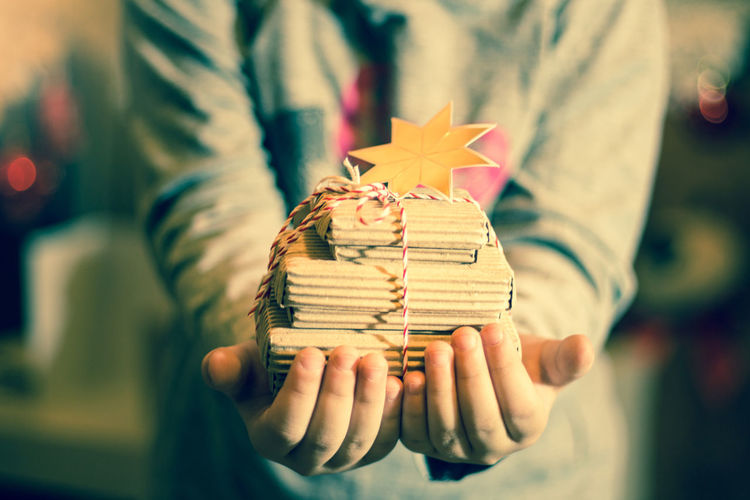 Midsection of girl holding christmas present at home