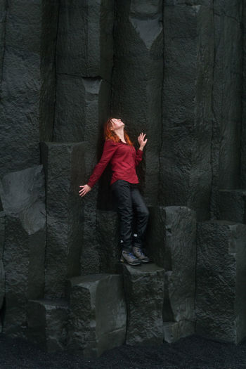 Brave woman posing on basalt columns scenic photography