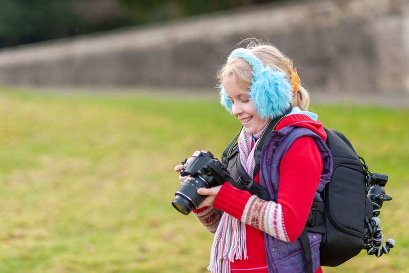 Full length of woman photographing on field
