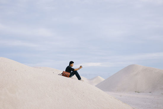 Full length of man on sand dune against sky