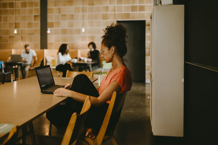 Businesswoman using laptop while working in coworking office