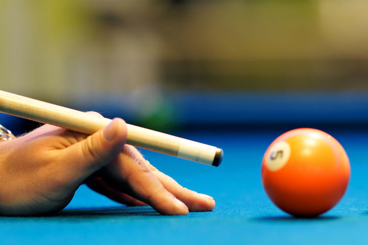 Cropped hand of man playing pool
