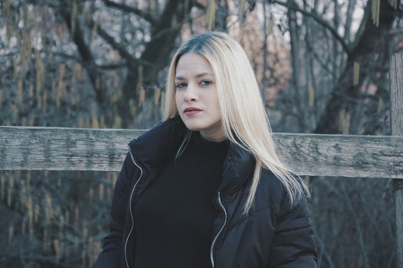 Portrait of beautiful young woman standing in forest