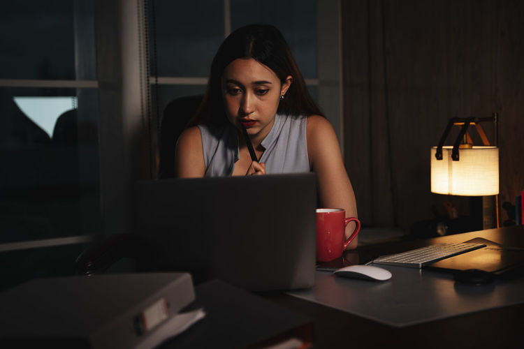 Depressed girl using laptop sitting at home
