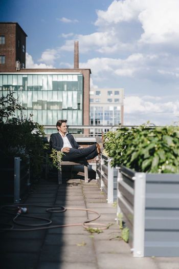 Businessman relaxing in his urban rooftop garden