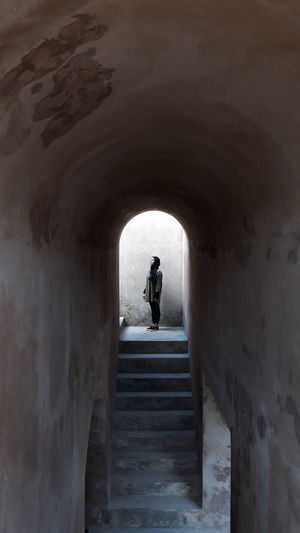 Woman standing in tunnel