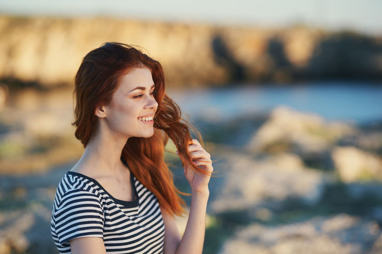 Beautiful young woman looking at sea shore