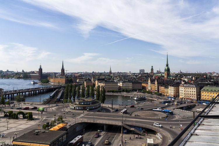 Elevated roads by lake at gamla stan against sky