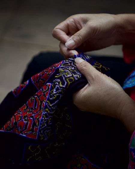 High angle view of woman stitching fabric