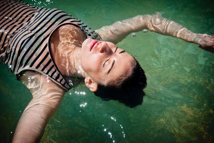 High angle view of woman floating on water in sea