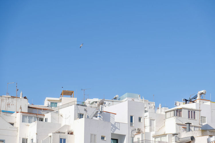 Low angle view of white buildings against clear blue sky