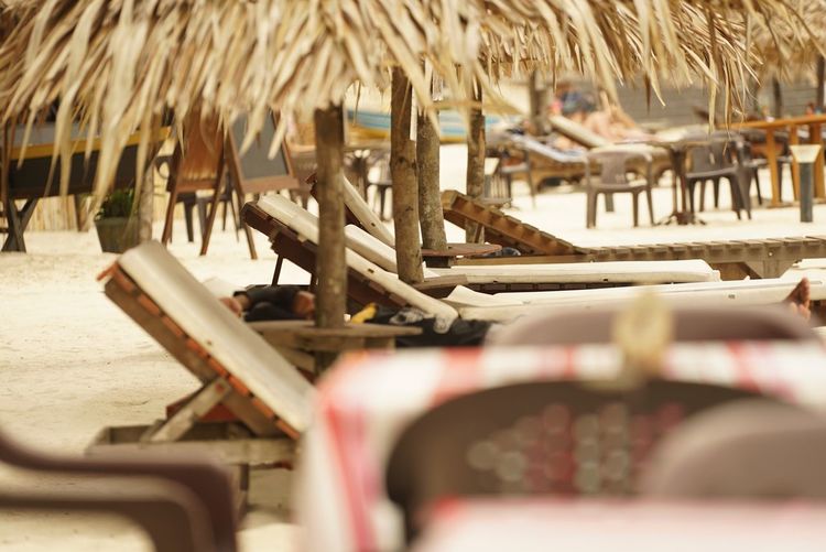 Close-up of deck chairs on beach