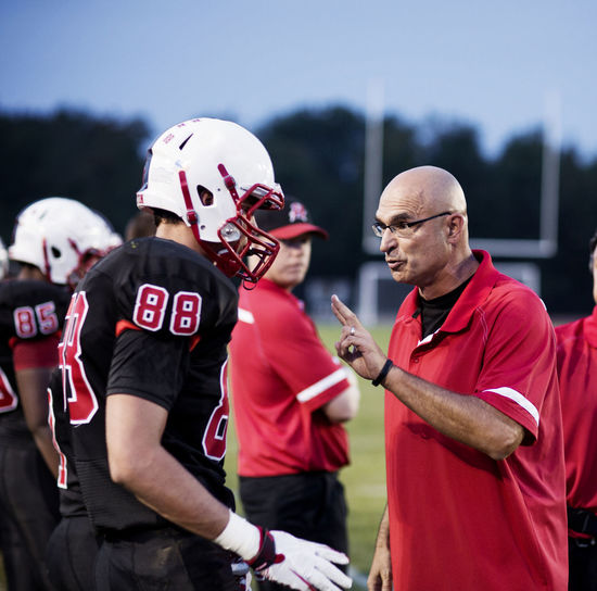Coach explaining american football players on field