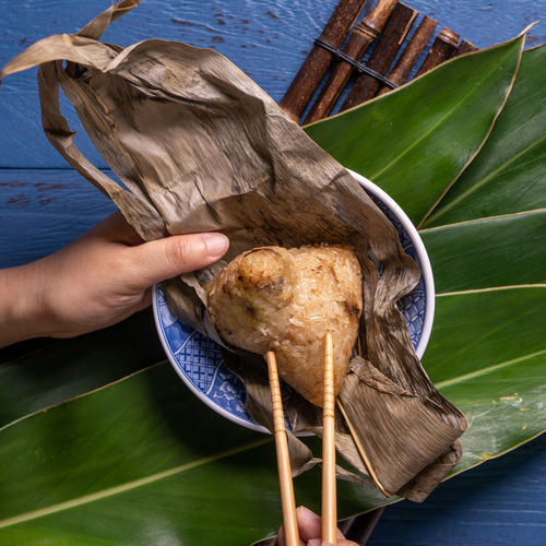 Close-up of hand holding food on leaves