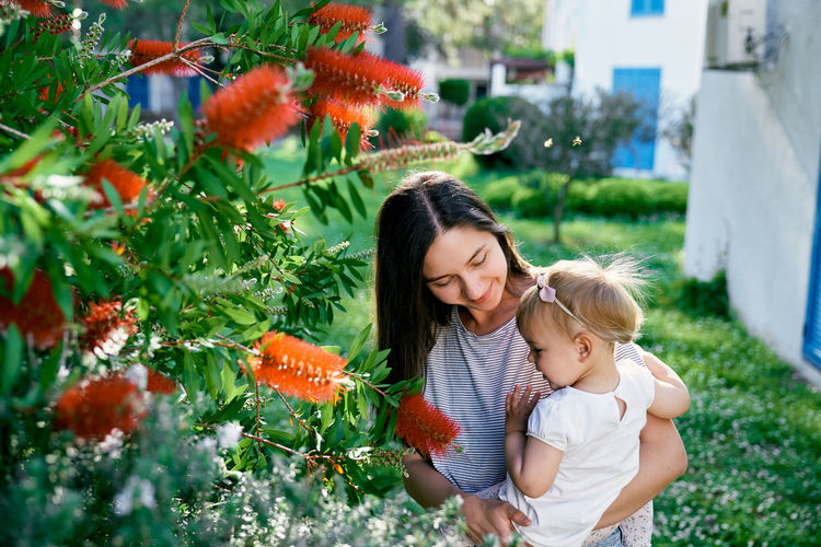 Mother and daughter standing by plants
