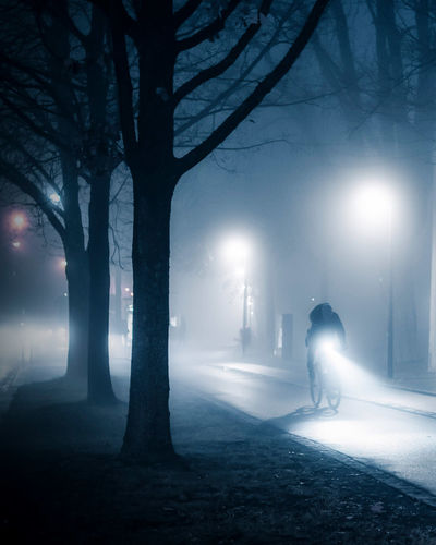 Man walking on snow covered street at night