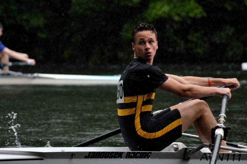 Teenager rowing boat during race in river