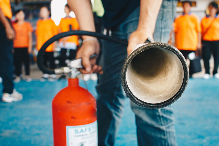 Close-up of firefighter holding fire extinguisher