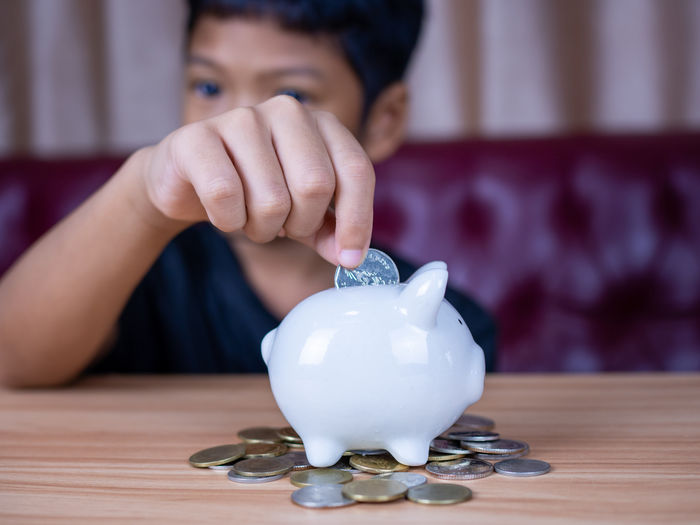 Boy saving money in a white pig piggy bank.saving concept. saving for the future.