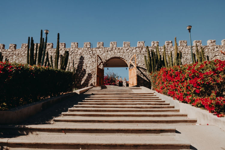 Staircase leading towards historic building against clear blue sky