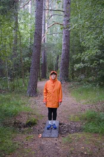 Full length of man standing by tree in forest