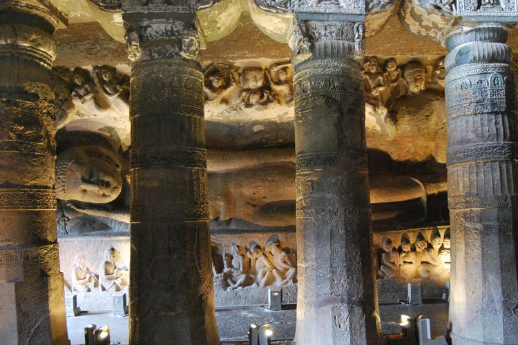 Columns against reclining buddha statue at illuminated ajanta caves