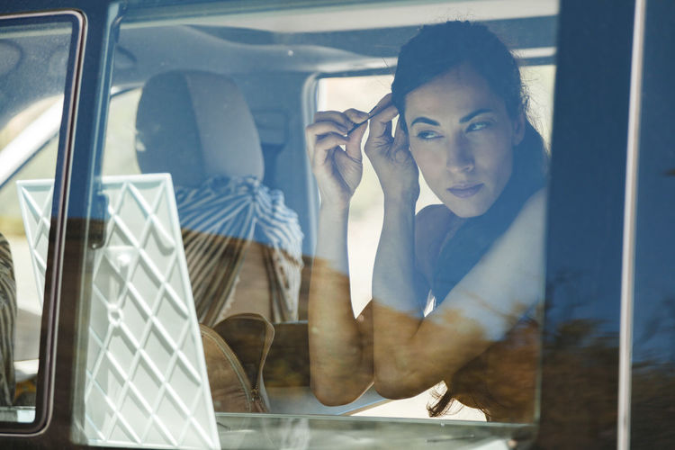 Portrait of young woman sitting in car