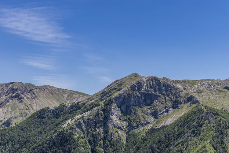 Panoramic view of landscape and mountains against blue sky