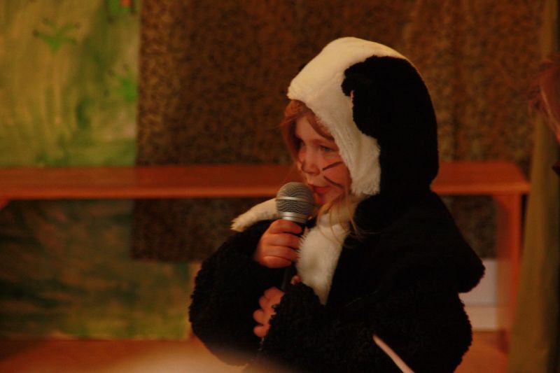 Child in animal costume giving speech on stage