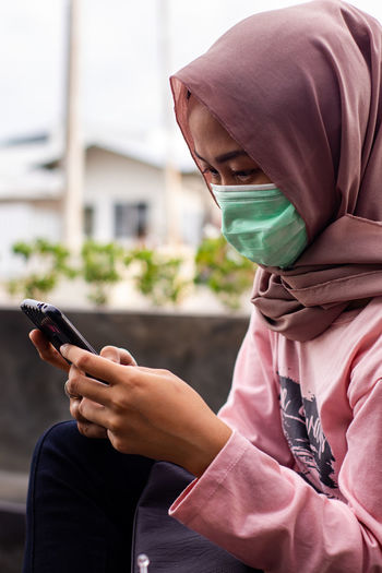 Midsection of man using mobile phone