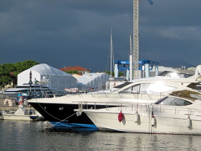Sailboats moored at harbor