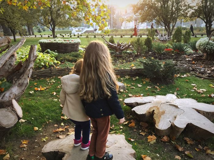 Rear view of siblings standing at park