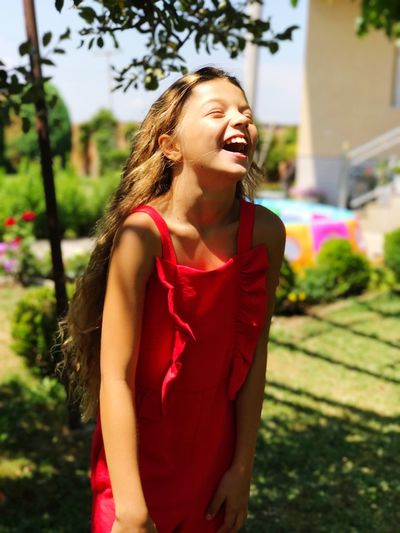 Cheerful teenage girl standing outdoors