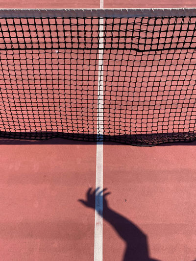 Shadow of hand on tennis court
