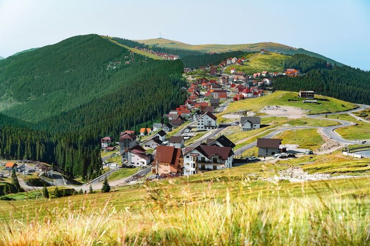 Houses on field by mountain against sky. mountain resort in summer